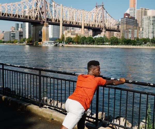Man stretching outdoors feeling refreshed and energetic in the morning sun.
